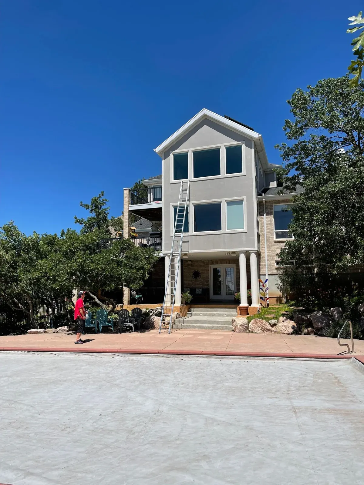 Multi-story home with large windows and light siding